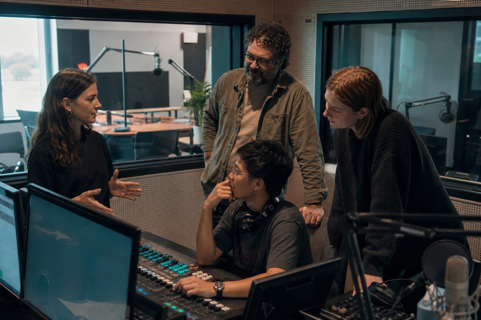 A media technology team collaborating in a radio control room