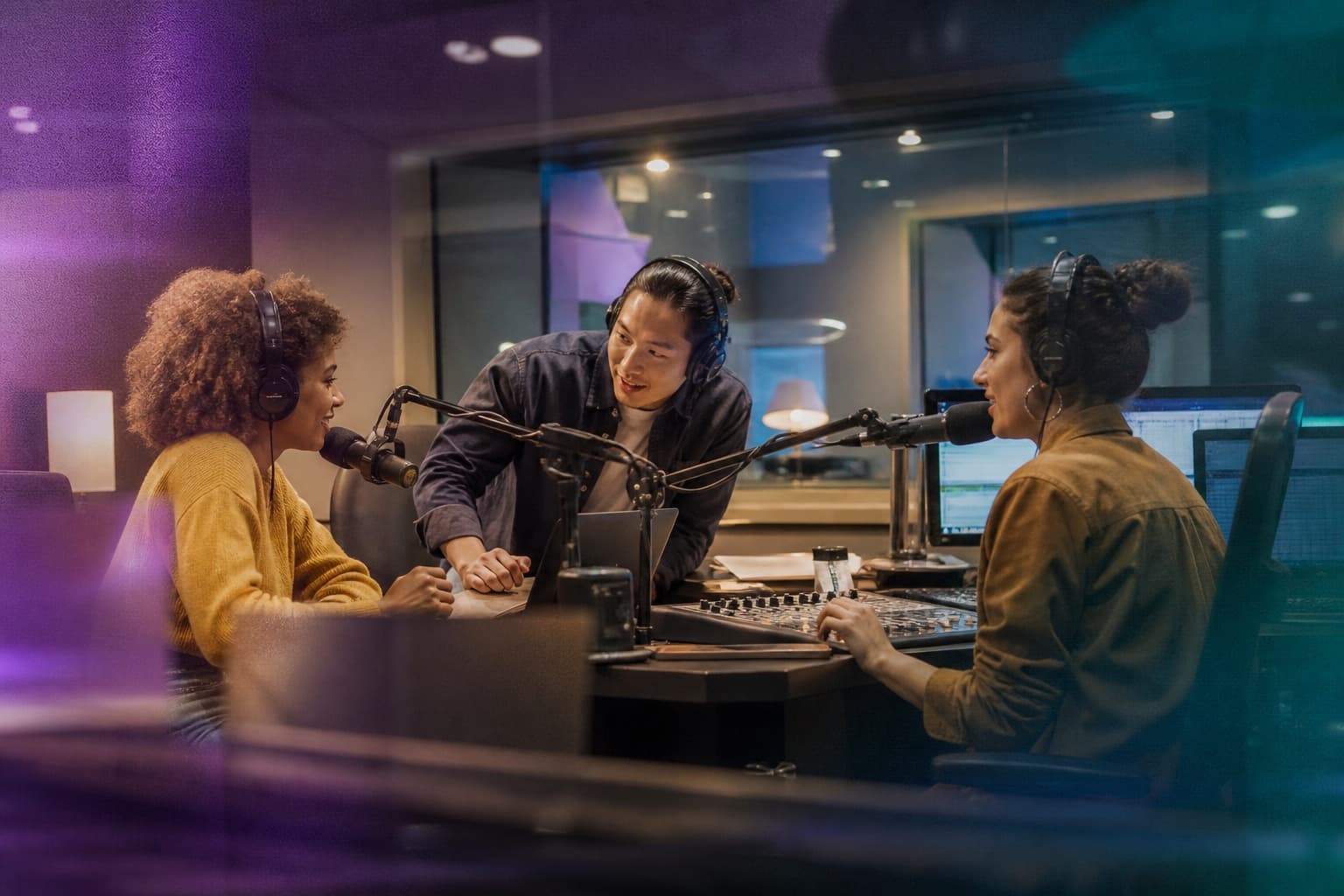 Two radio presenters and a producer preparing together before going live